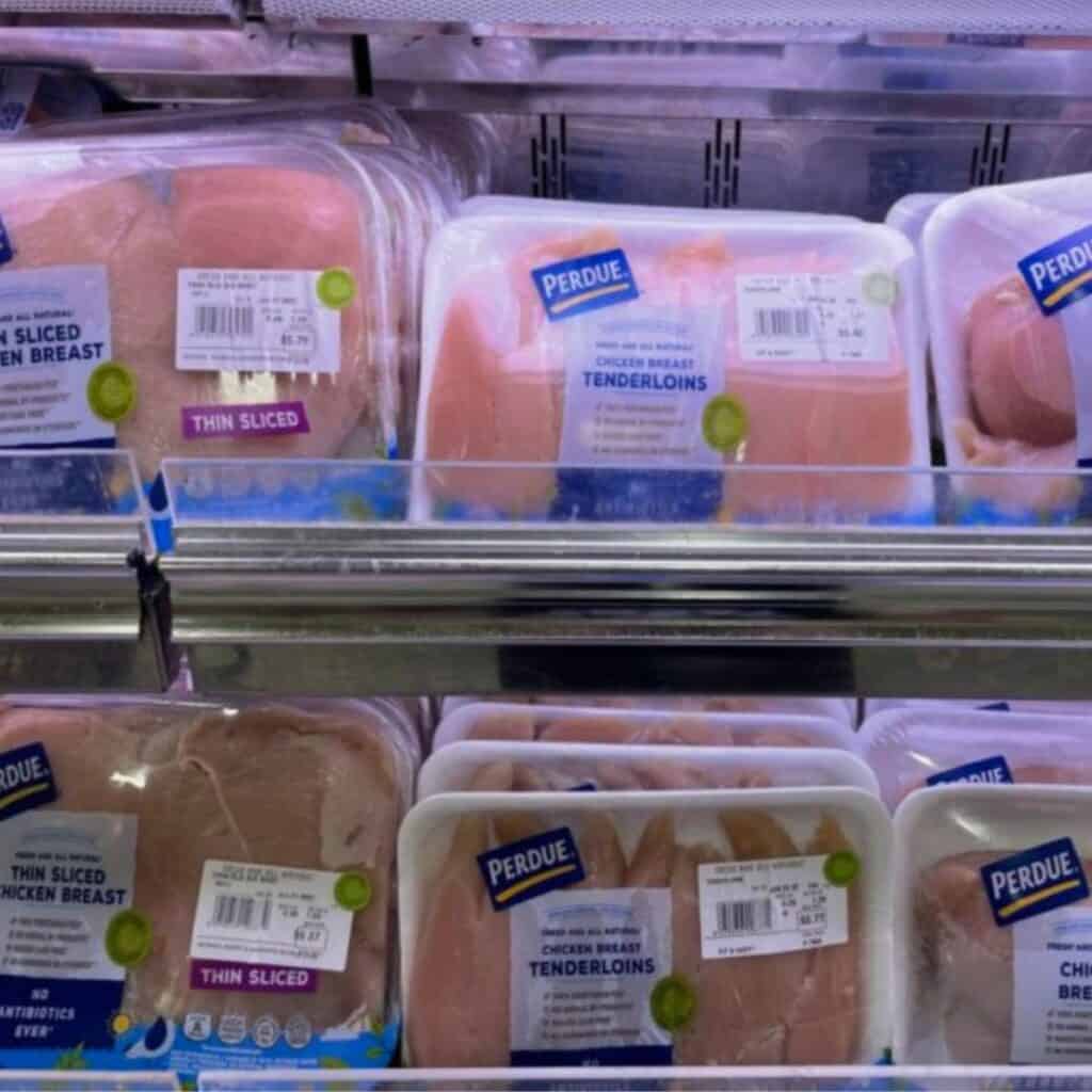 Packages of chicken breast on a supermarket shelf