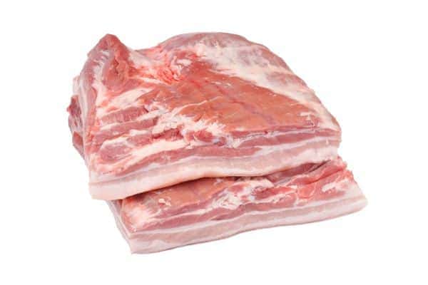 Two slabs of raw pork belly on a white background